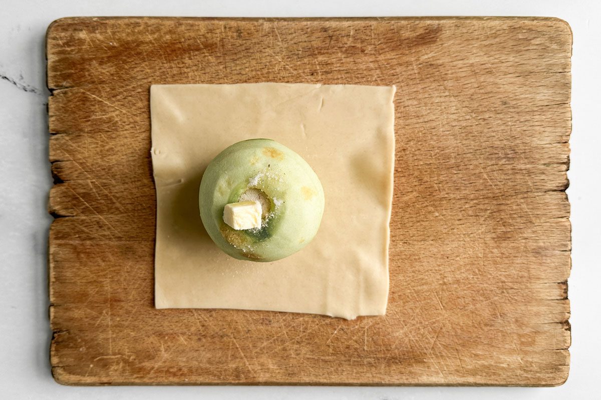 Apple on pie dough on a wooden board for Taste of Home Easy Apple Dumplings