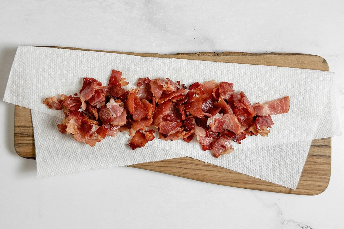 Cooked bacon for Taste of Home Farmers Breakfast on a paper towel lined wooden board