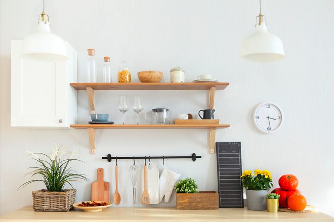 Interior of empty modern white kitchen with various objects