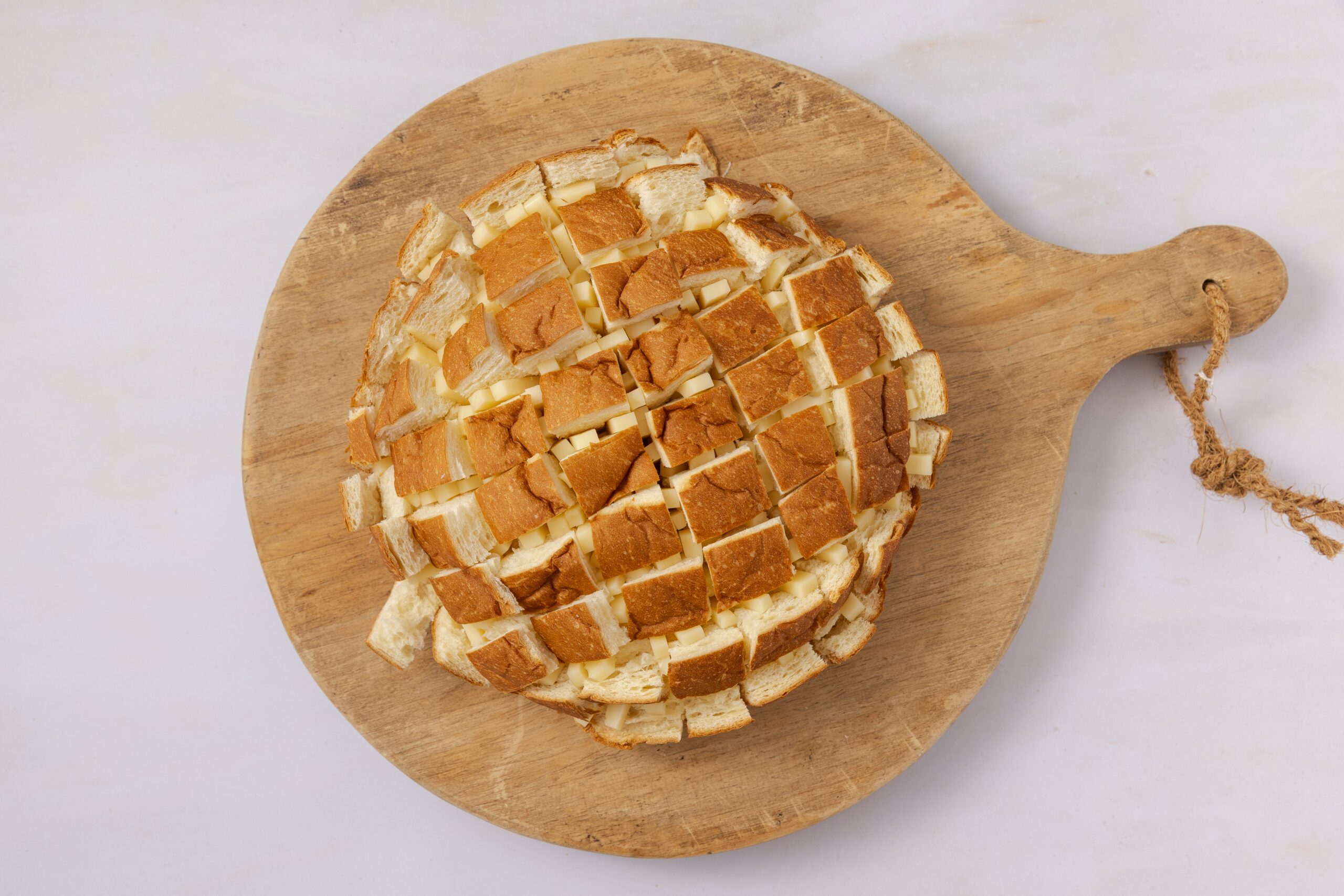 Hawaiian sweet bread being filled with cheese.