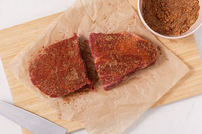 Beef chuck roast cut in half and rubbed with seasoning mix.
