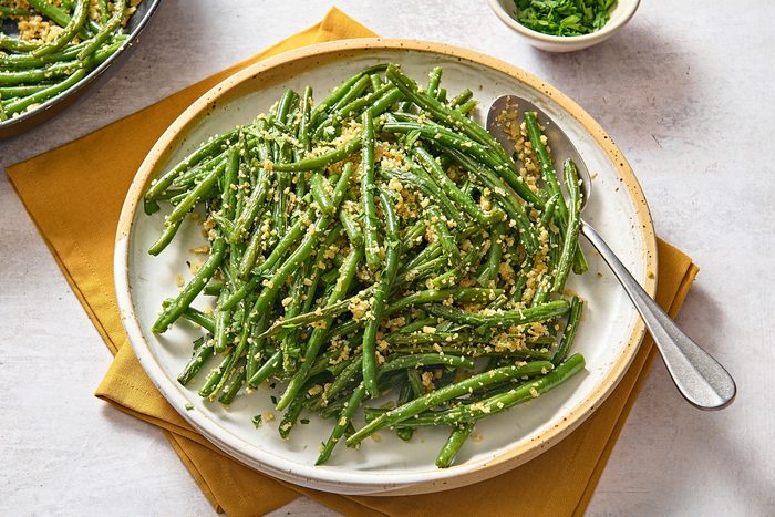 A big plate of Italian green beans with a serving spoon
