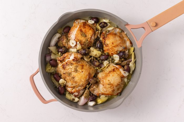 Olives, lemon juice, chicken broth, capers, garlic and zaatar added to the skillet before going into the oven.