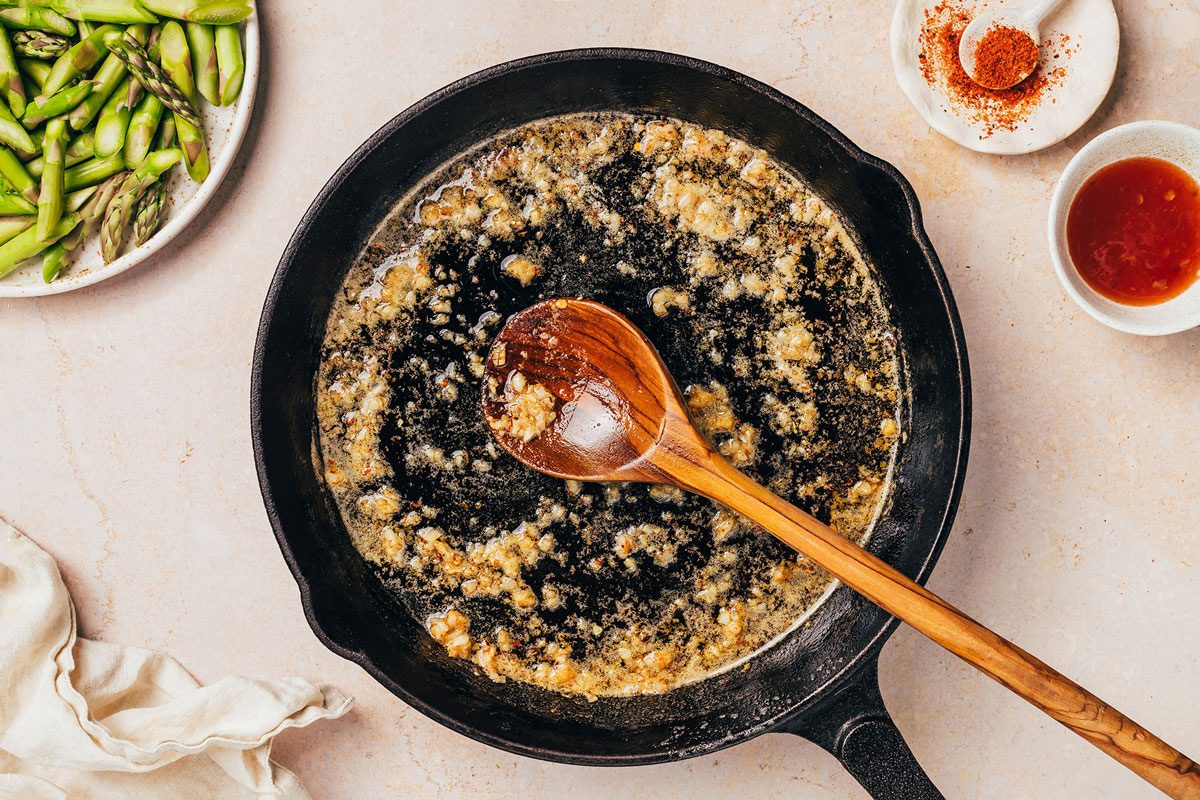 Garlic and red pepper flakes being cooked in butter and oil for the Pasta with Asparagus recipe by Taste of Home