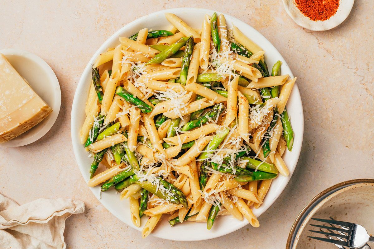 Pasta with asparagus served in a large bowl topped with parmesan recipe by Taste of Home