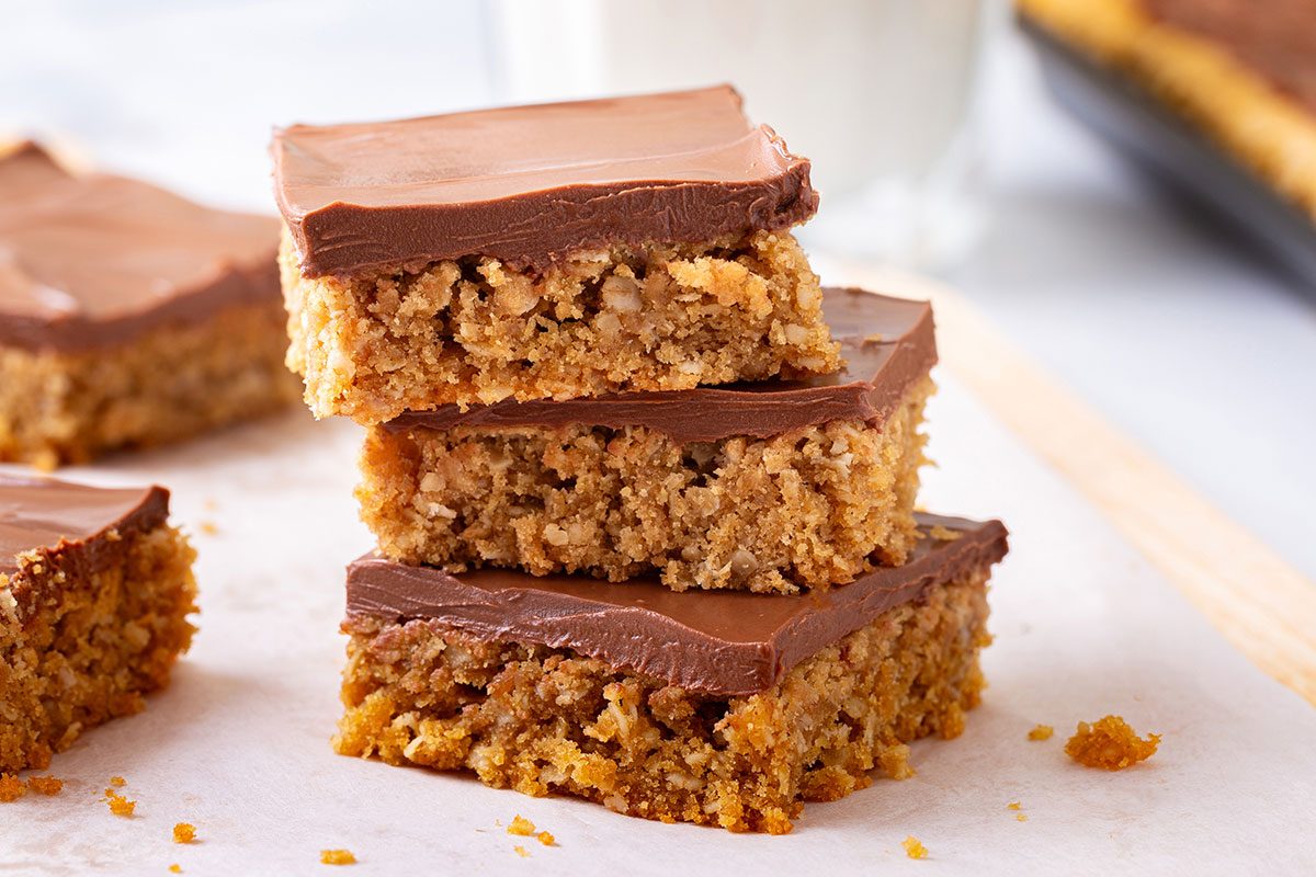Stack of three cut out Peanut Butter Cookie Bars on a wooden cutting board for Taste of Home