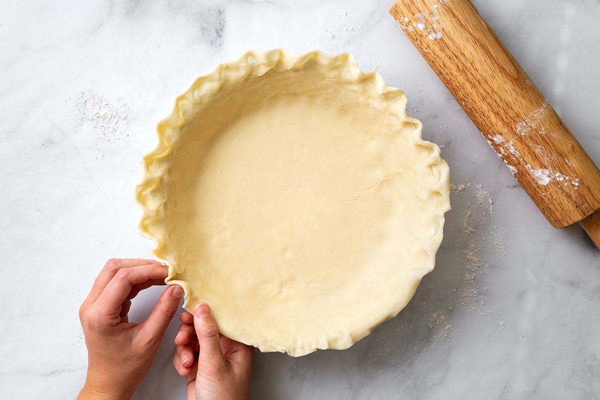 Pie dough in a 9 inch pie plate with flutted edges for step one of Pecan Pie without Corn Syrup recipe for Taste of Home