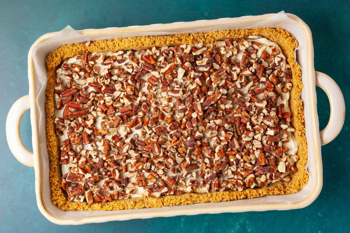 Step 2 of Taste of Home Pecan Pie Cheesecake Bars is to beat the cream cheese, sugar and vanilla just until smooth. Spread on top of the crust. Next, add the layer of chopped pecans.