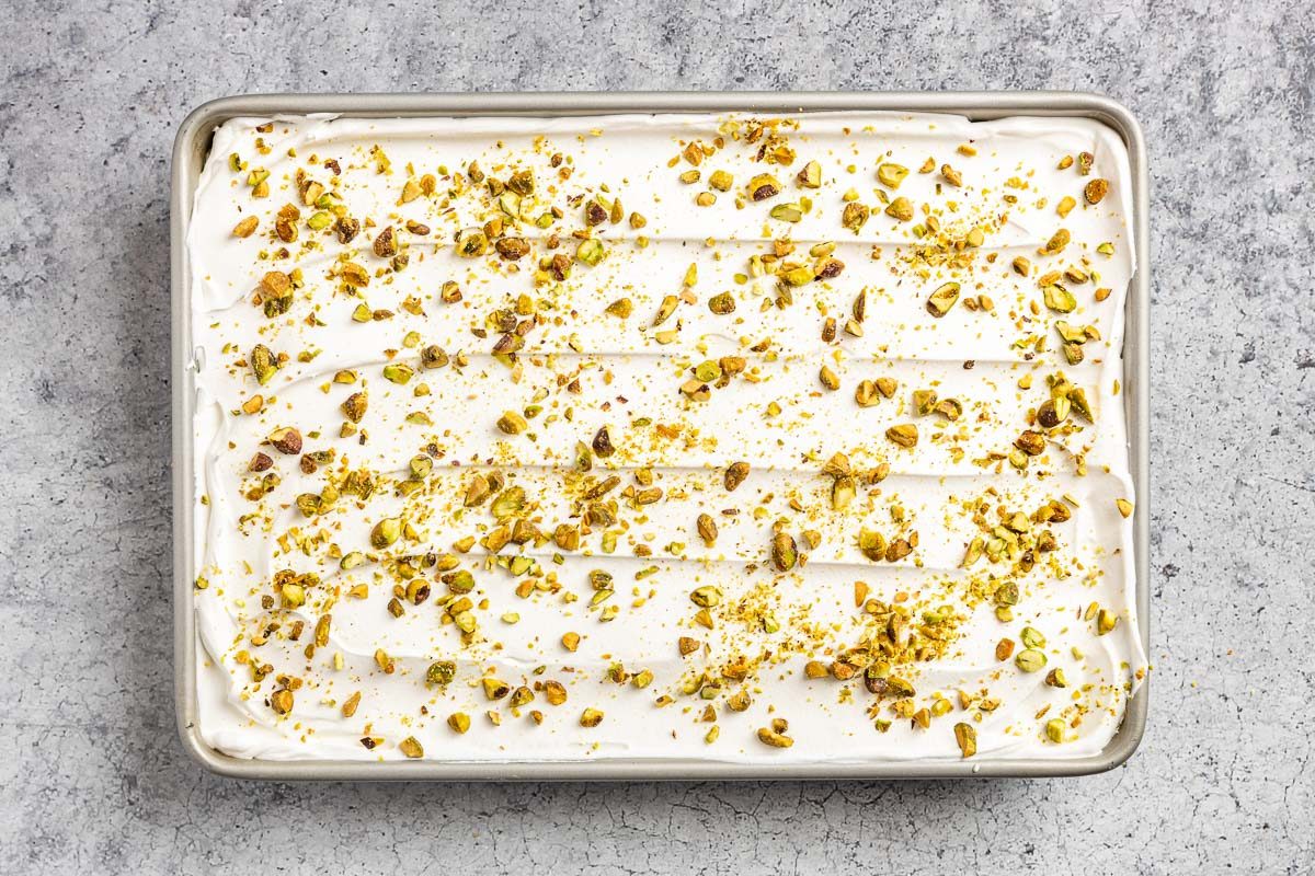 Taste of Home Pistachio Pudding Dessert photo of the whipped topping layer with chopped pistachios.