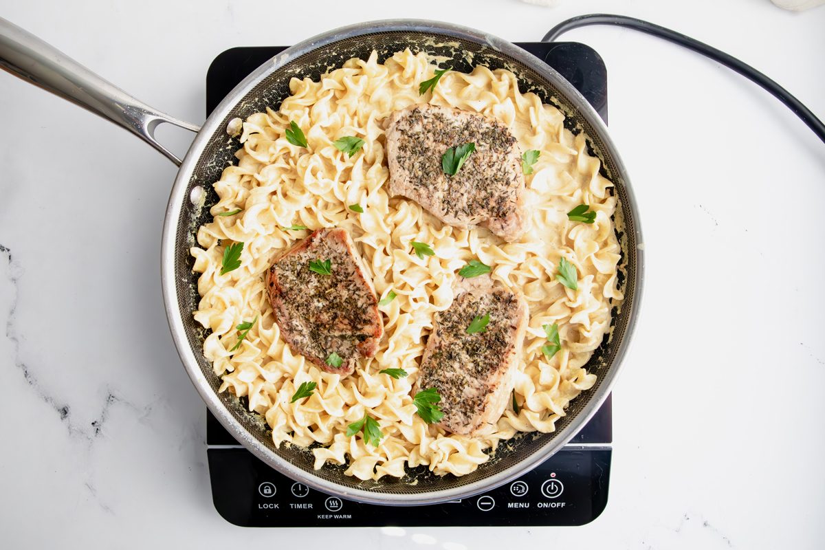 Overhead shot for Taste of Home Pork Chops and Noodles, all ingredients cooked in a skillet.
