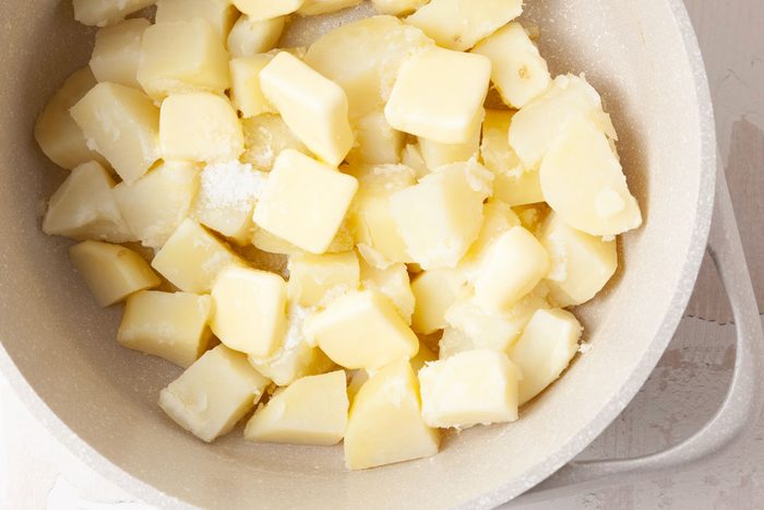 Step 2 of Taste of Home Potato Puree is to place the potatoes in a Dutch oven and add enough water to cover them. Season the water with 1/2 teaspoon of salt and bring to a boil. Next, reduce the heat and cook the potatoes, uncovered, until they are very tender, which will take 20 to 25 minutes. Then, drain the liquid and return the potatoes to the Dutch oven pan. Stir in the salt and 8 tablespoons of cubed butter and stir until the butter has melted.