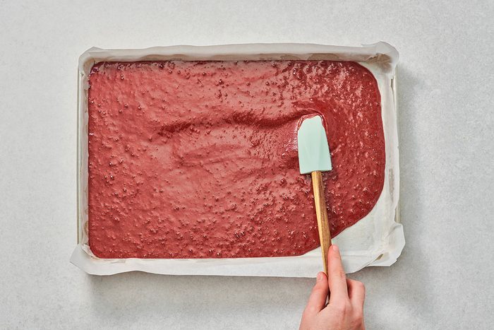 Spreading red velvet cake batter in a pan