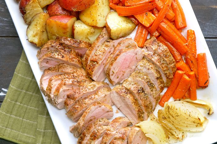 Roasted Pork Tenderloin served in a white plate on a wooden table