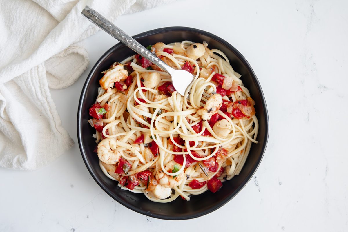 Beauty shot for Taste of Home Seafood Linguine being served in a black bowl.