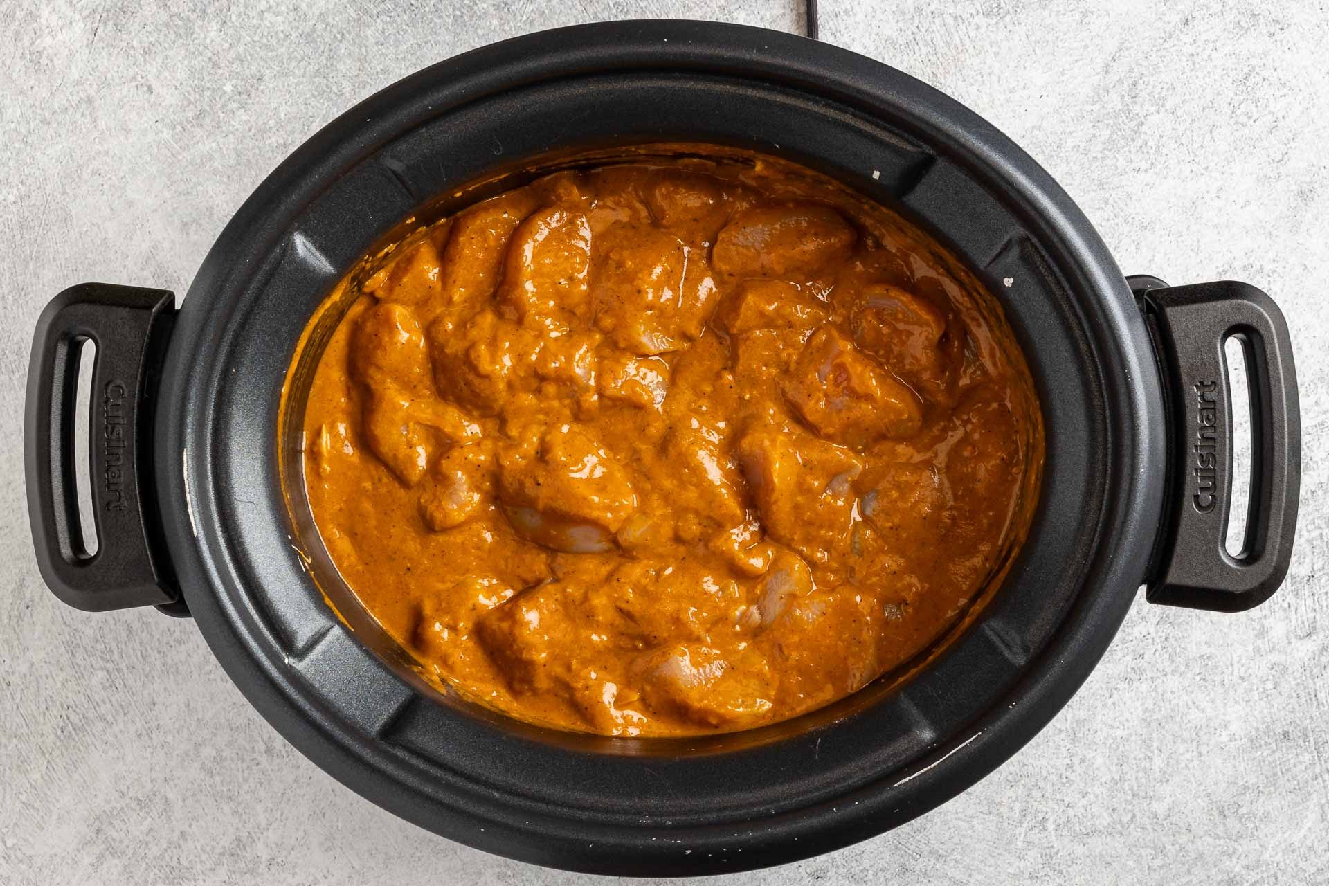 combining the sauce and chicken in a slow cooker.