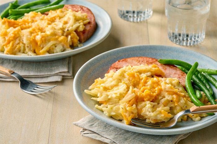 3/4th Shot Of Crockpot Cheesy Potatoes served on two plates