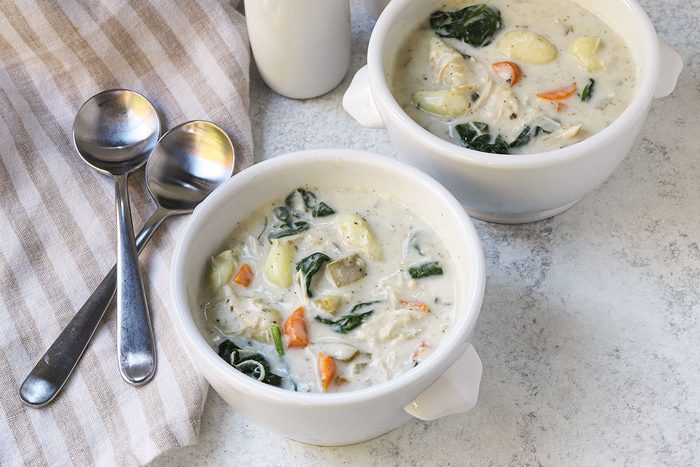 Servings of slow cooker chicken gnocchi soup with spinach and vegetables.