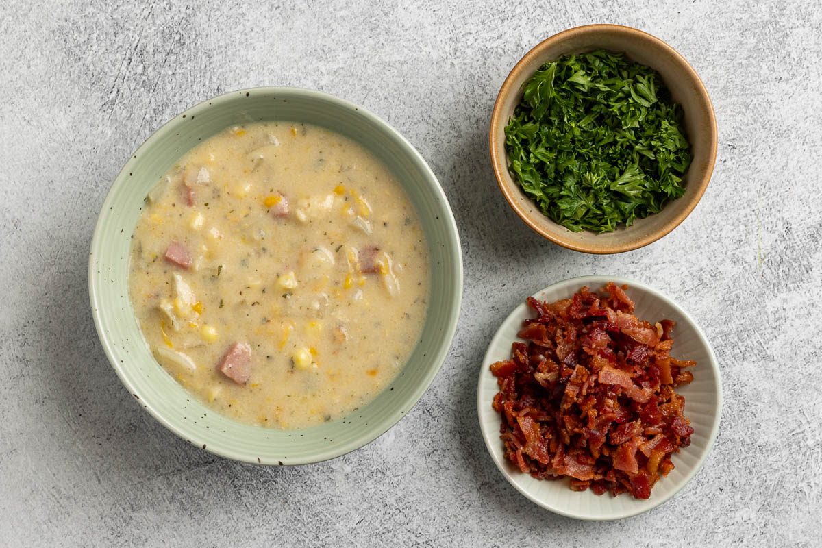 Serving Slow Cooker Corn Chowder with toppings