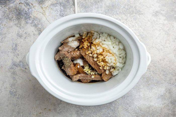 beef and other ingredients set into the crock pot.
