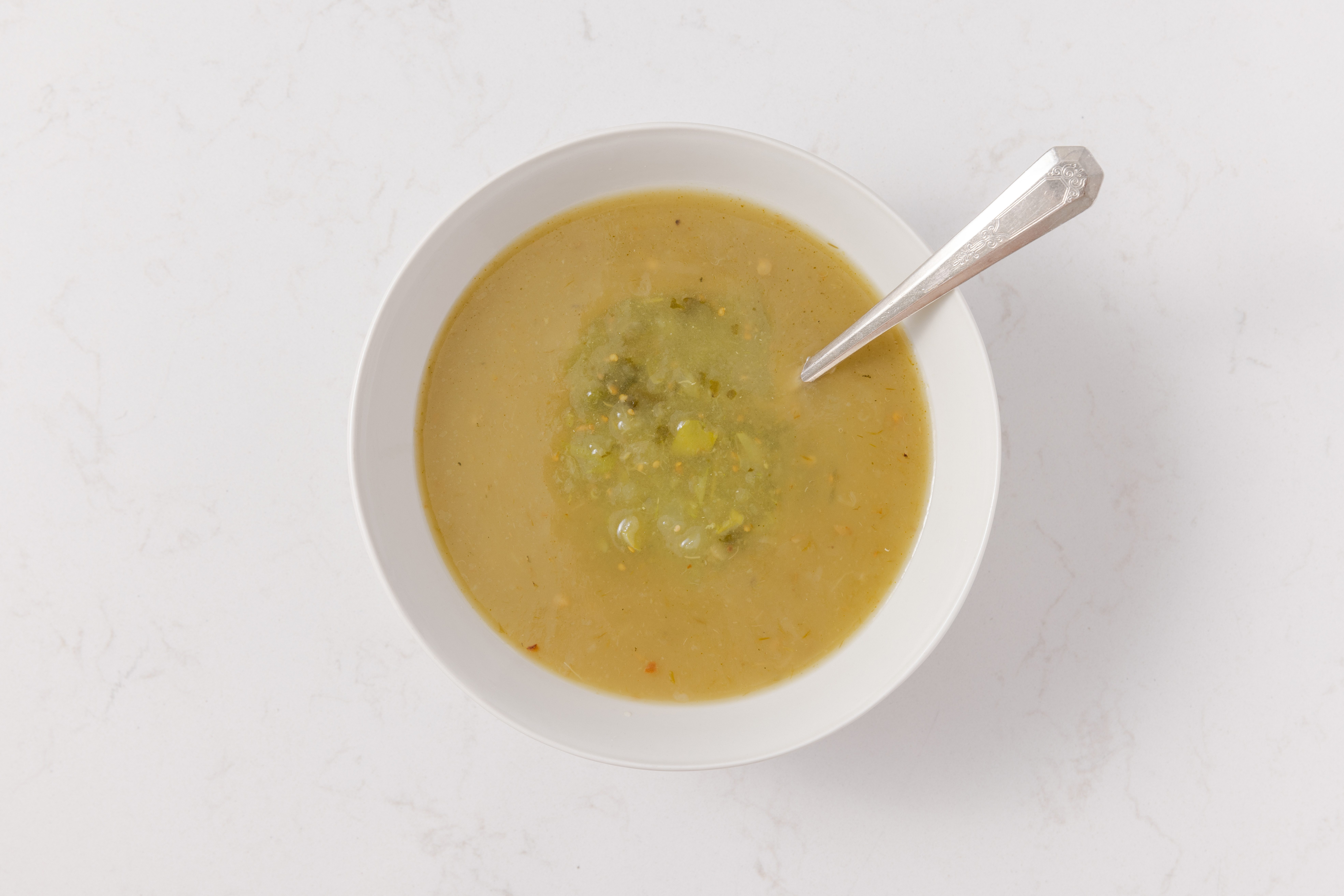 Green enchilada sauce and salsa verde being combined in mixing bowl.