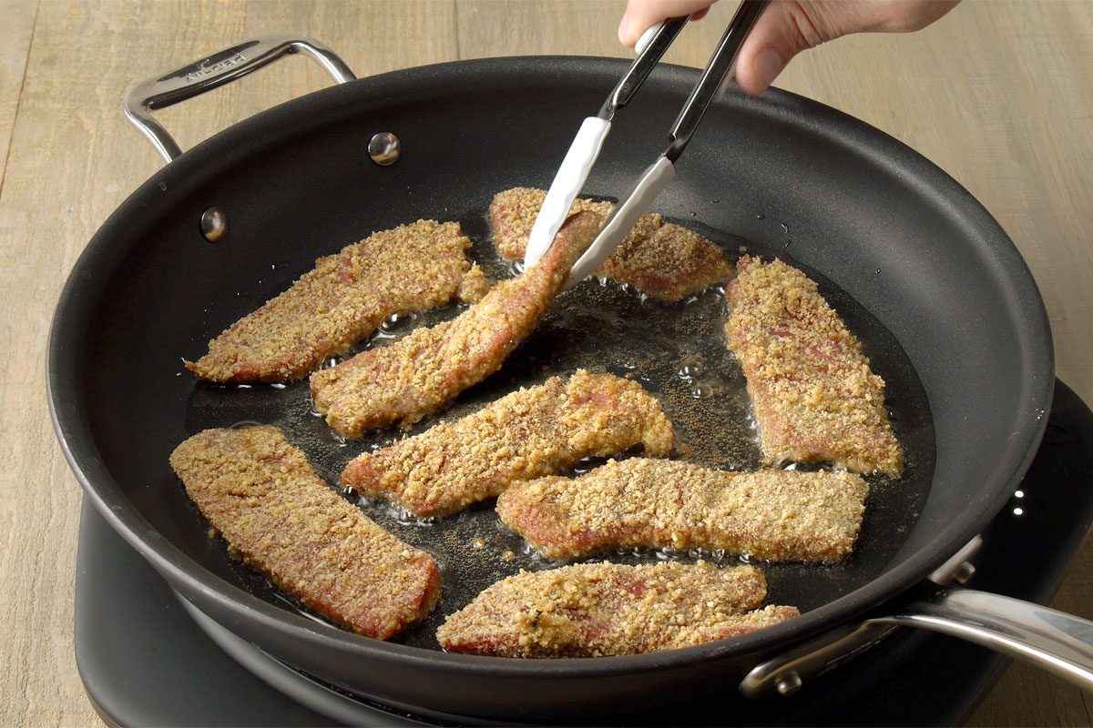 Steak fingers frying in a pan