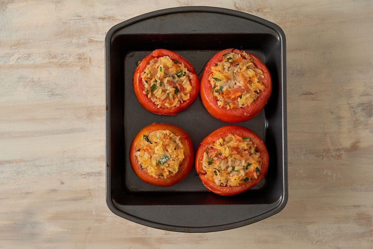 Stuffed tomatoes in a baking dish, ready to bake for the Stuffed Tomatoes with Rice recipe, by Taste of Home.