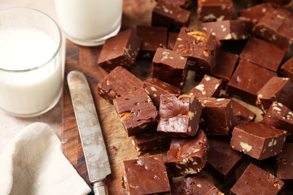 Close up of Taste of Home's Velveeta Fudge sliced on a cutting board on a brown marble surface.
