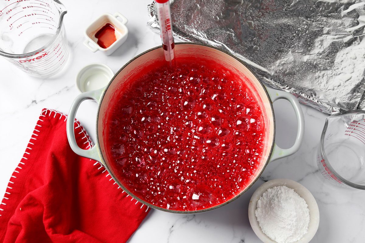 Process of making Taste of Home's cinnamon hard candy in a baking sheet on a grey marble surface.