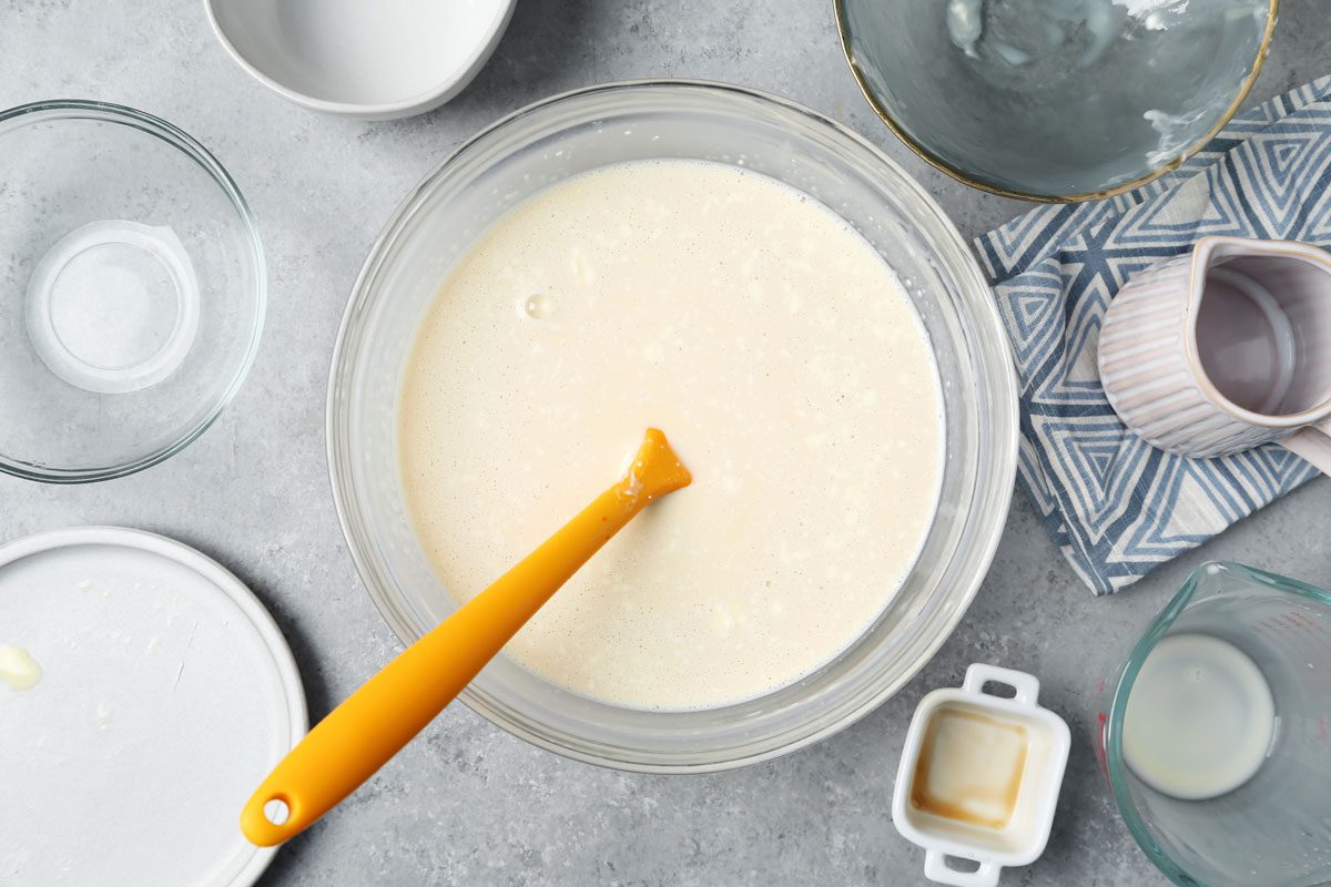 Process of making Taste of Home's Flan de Queso. Making the batter in a bowl on a grey surface.