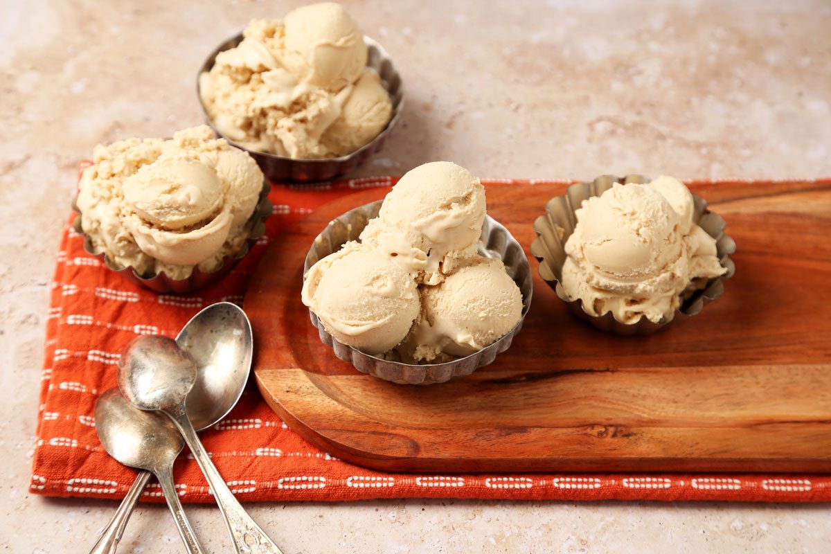 Close up of Taste of Home's Peanut Butter Ice Cream served in small metal bowls on a brown marble surface.