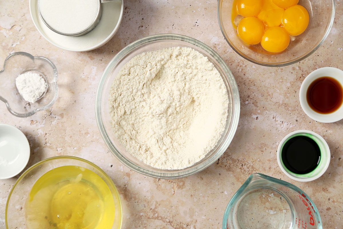 Process of making Taste of Home's Pandan Cake making the cake batter in a large mixing bowl on a brown marble surface.