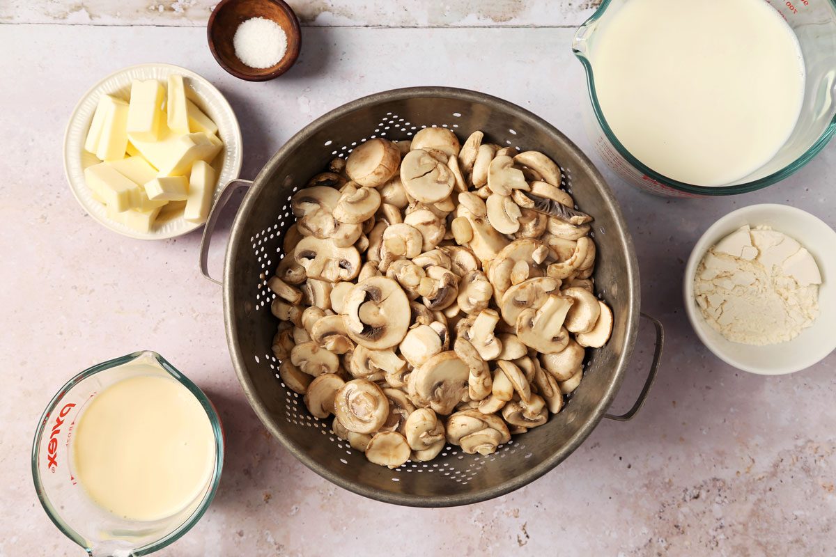 Process of making Taste of Home's Creamed Mushrooms in a large pot on a grey surface.