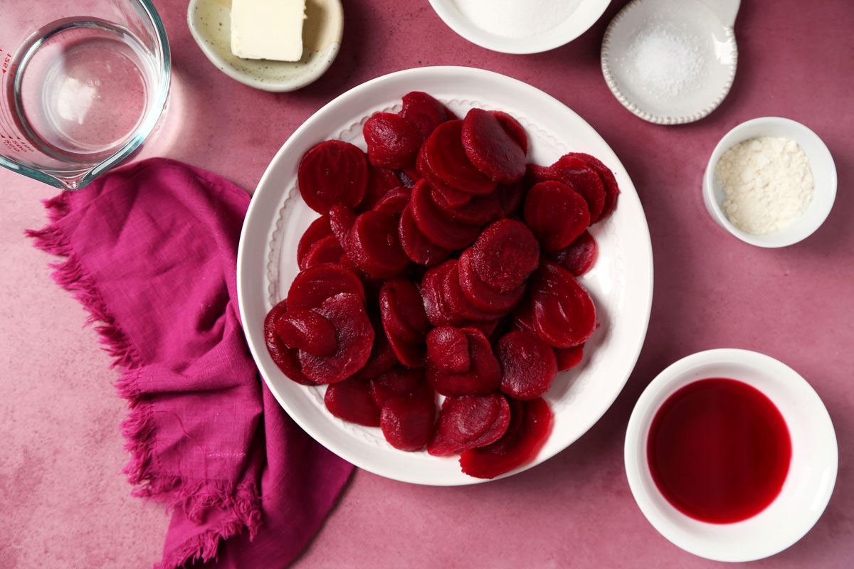 Process of making Taste of Home's Harvard Beets sliced beets in a bowl on a magenta surface.