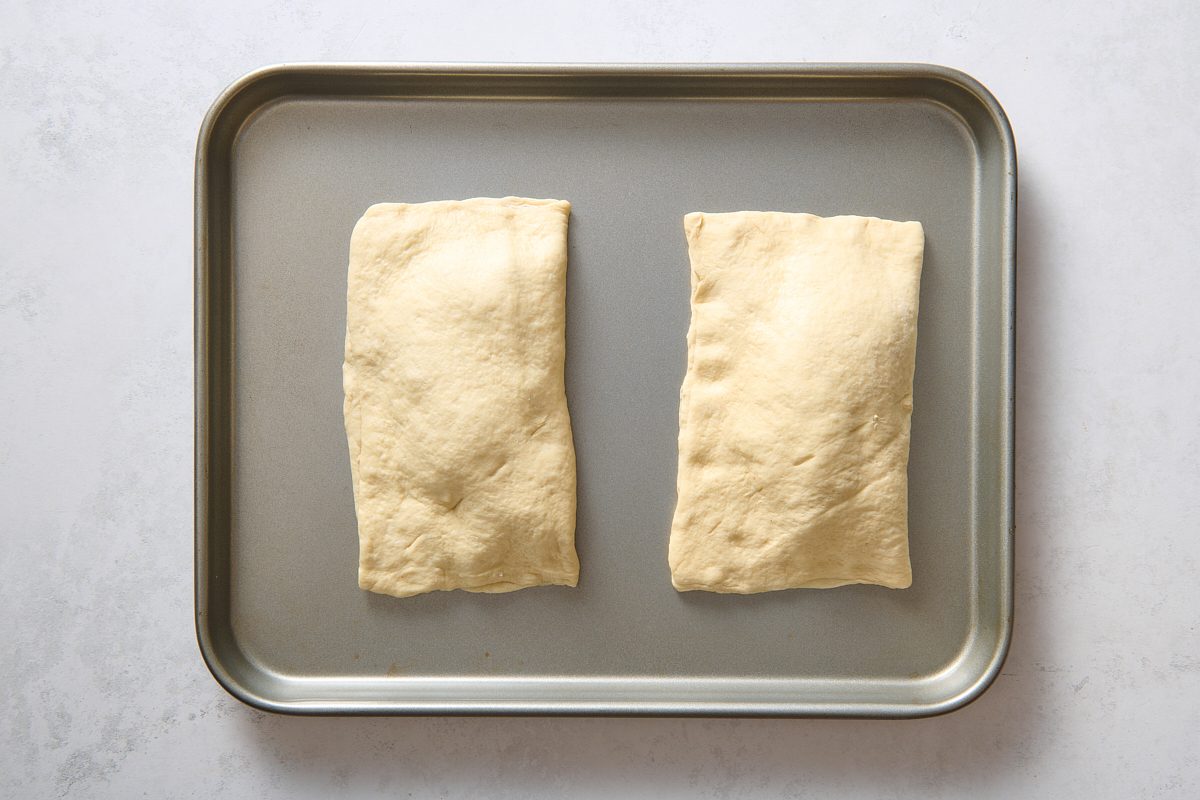 Unbaked taco pockets on a baking sheet