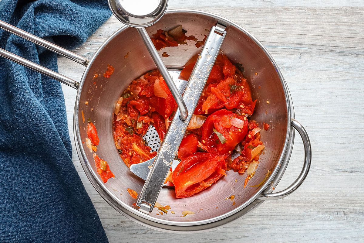 Spicy tomato juice preparation: cooked tomato and vegetable mixture in the food mill.