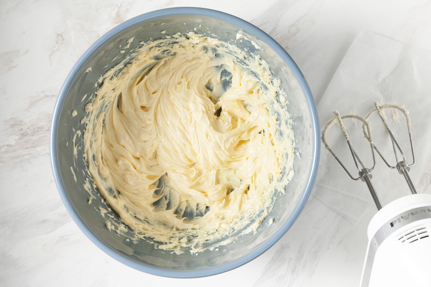 A large bowl filled with fluffy, beaten softened margarine.