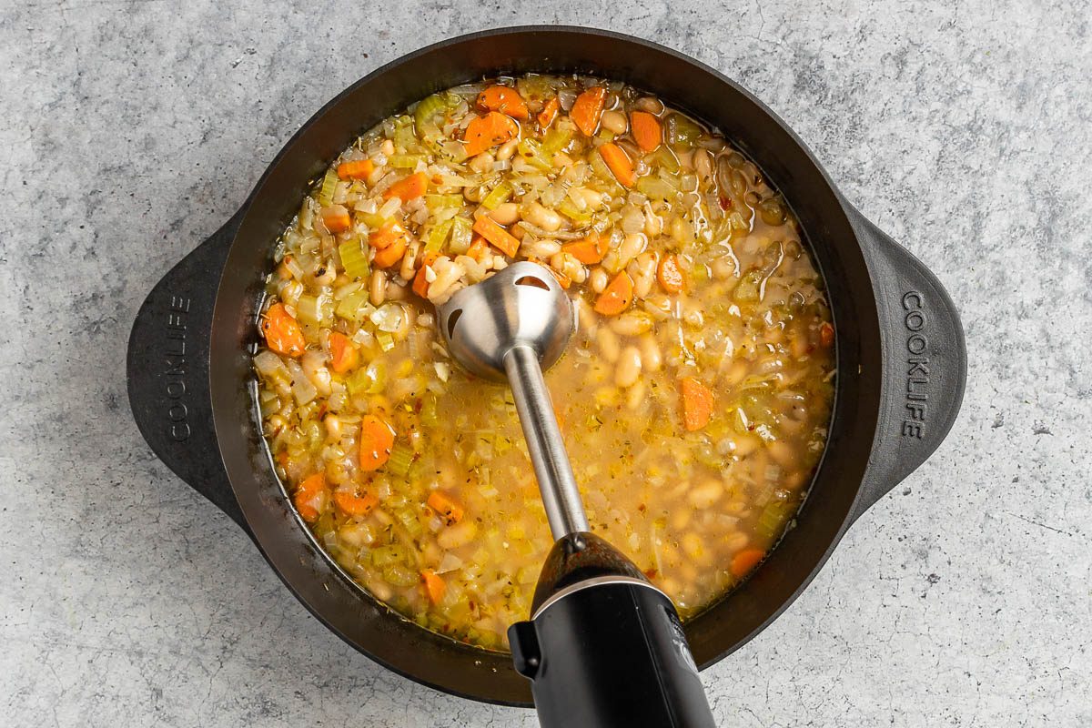 Taste of Home White Bean and Kale soup photo of blending the soup with an immersion blender.