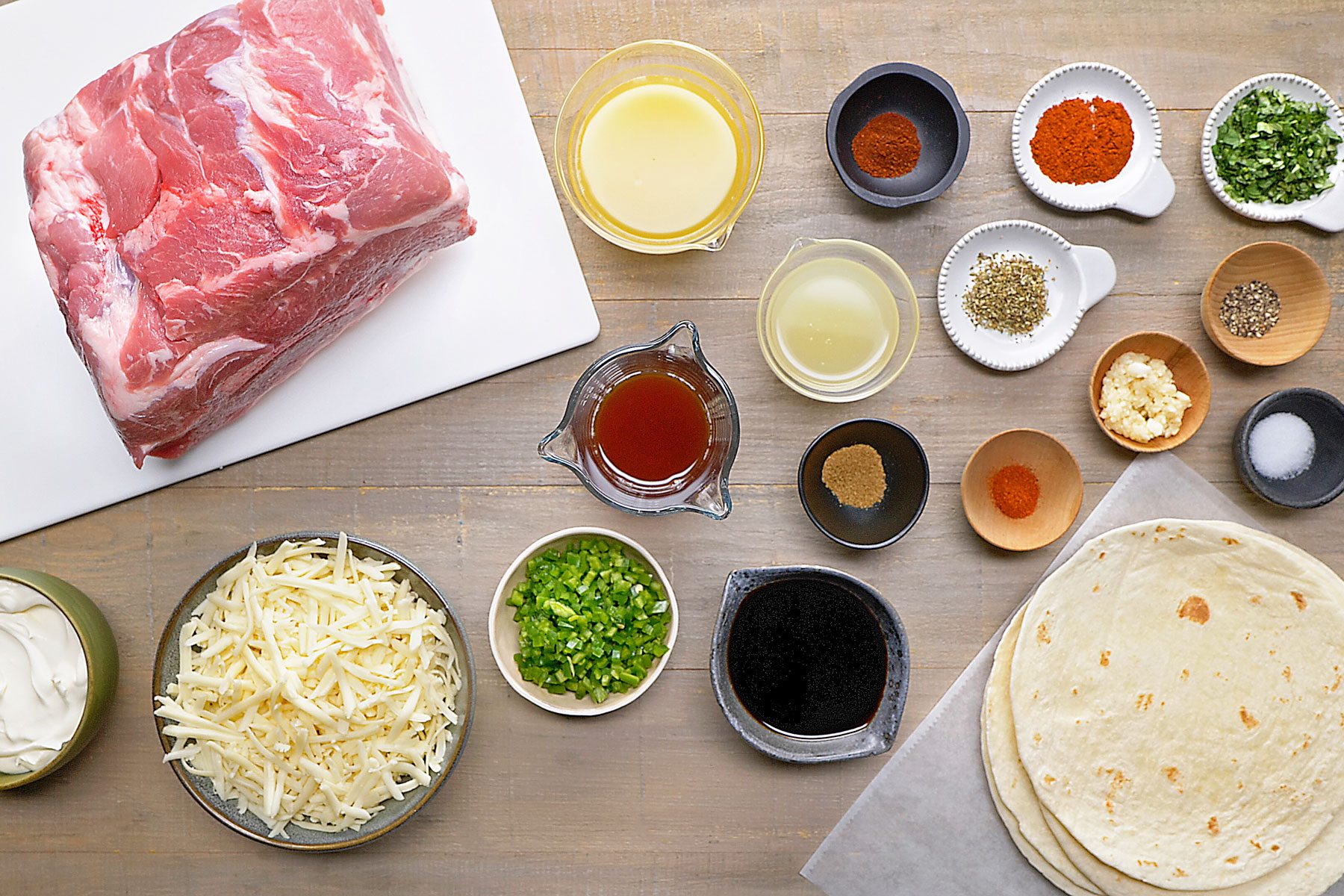 pork shoulder, seasonings, pineapple juice, soy sauce, beef stock, lime juice, peppers, tortillas, sour cream and cheese.