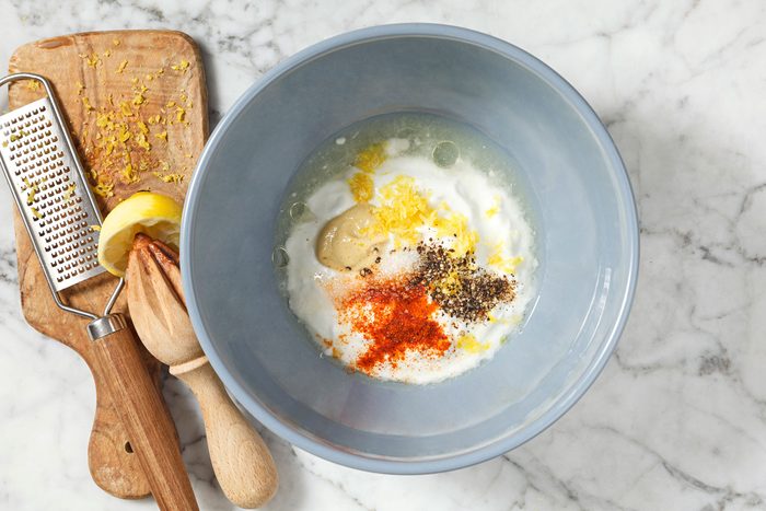 yogurt, lemon juice, olive oil, Dijon mustard, lemon zest, salt, pepper and cayenne pepper in a bowl