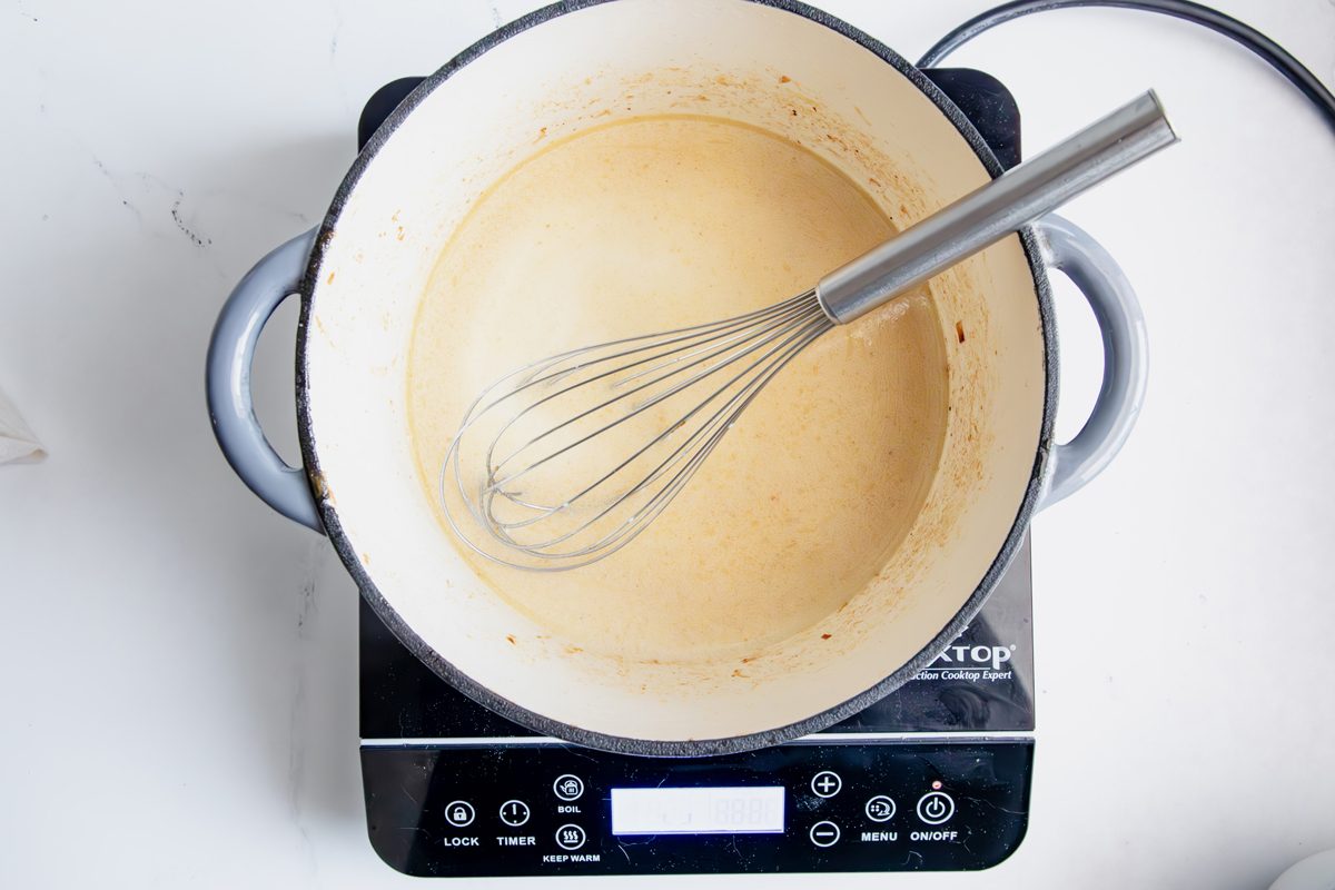Overhead shot for Taste of Home Creamed Onions, milk mixture cooking in a dutch oven.