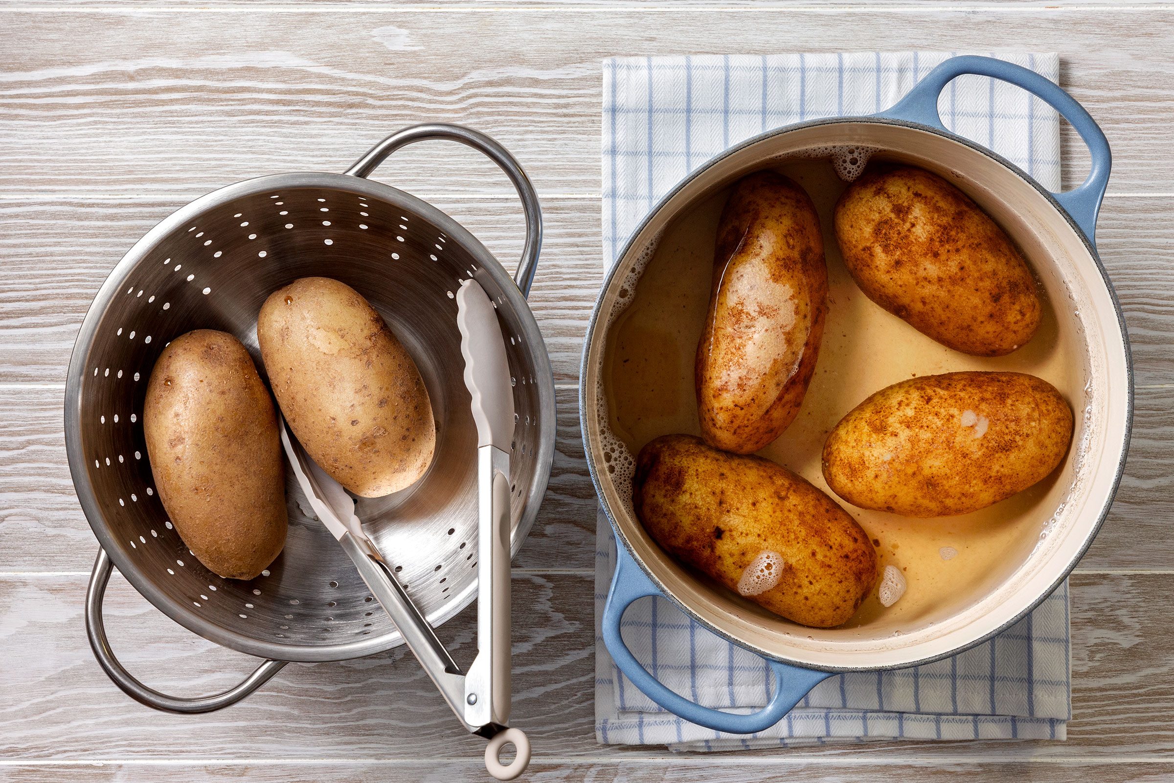 Boiled potatoes dipped in water and removed in a draining utensil