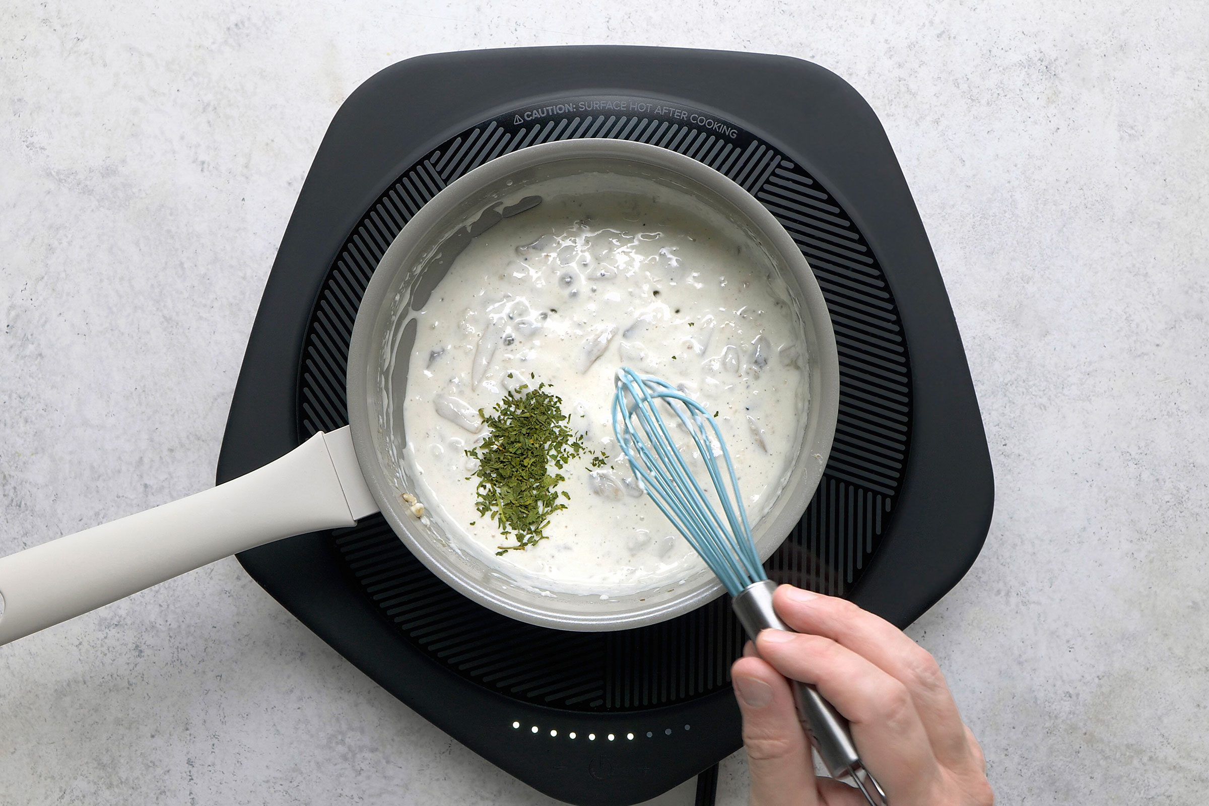 Parsley stirred into cream sauce in a saucepan