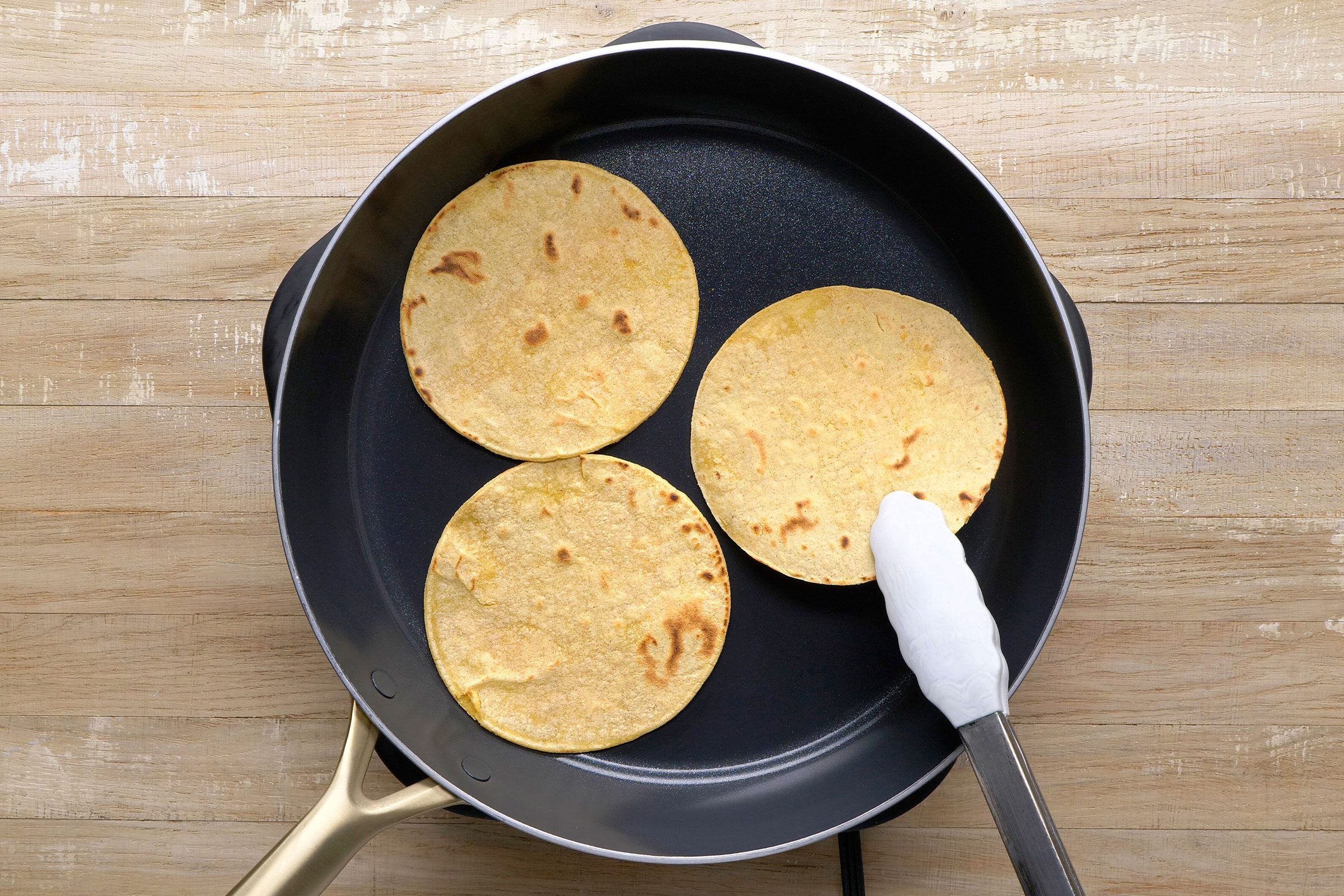 Roasting three tortillas in a large skillet