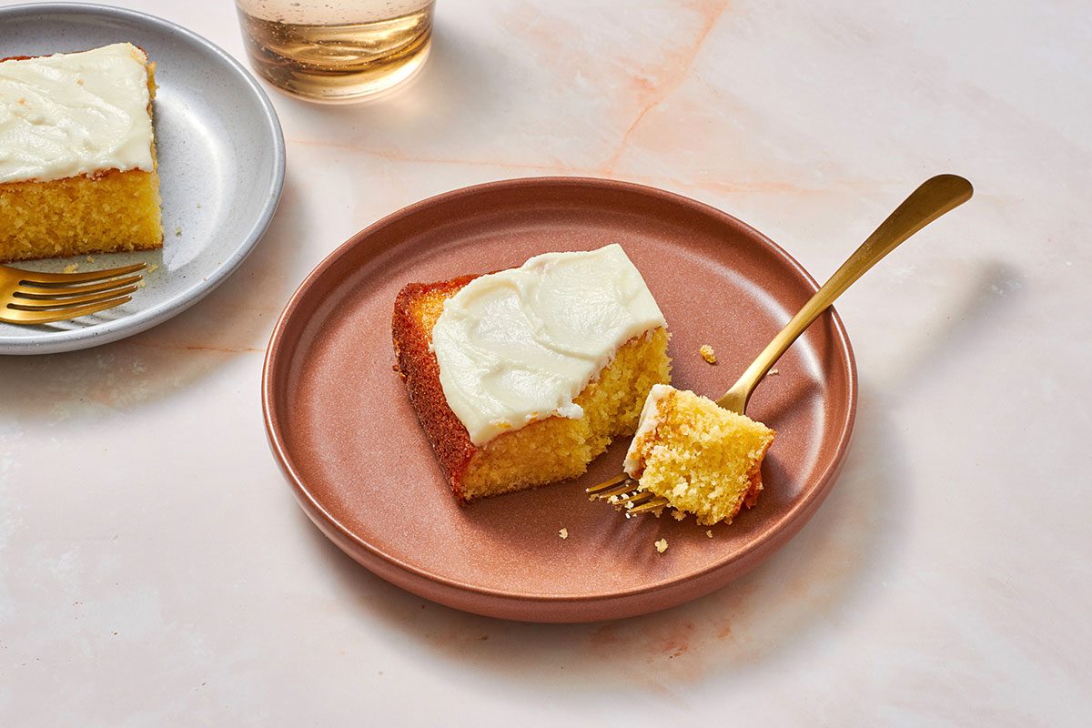 Orange cake in a pan with one portion removed