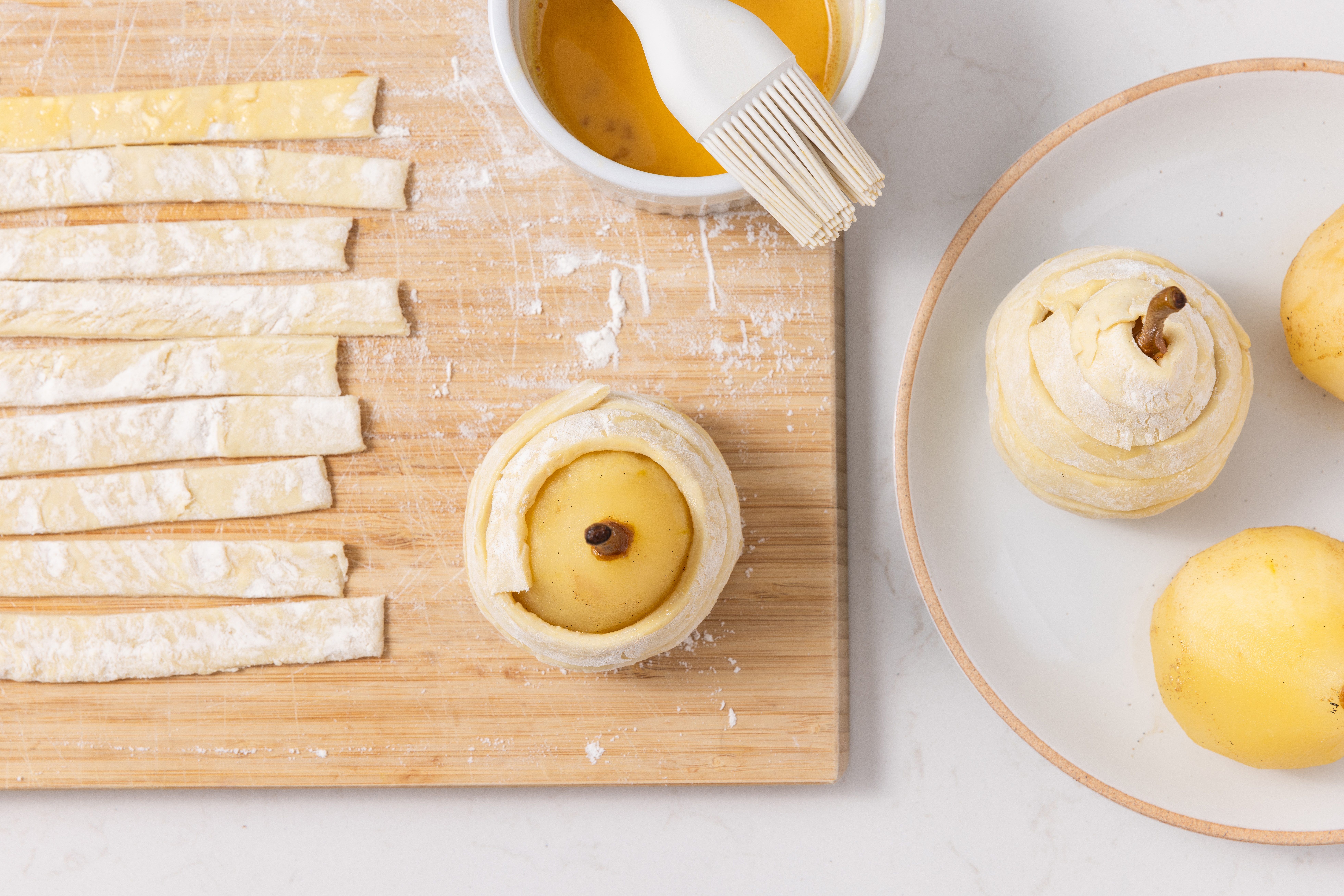Pears being wrapped in puff pastry to be baked.