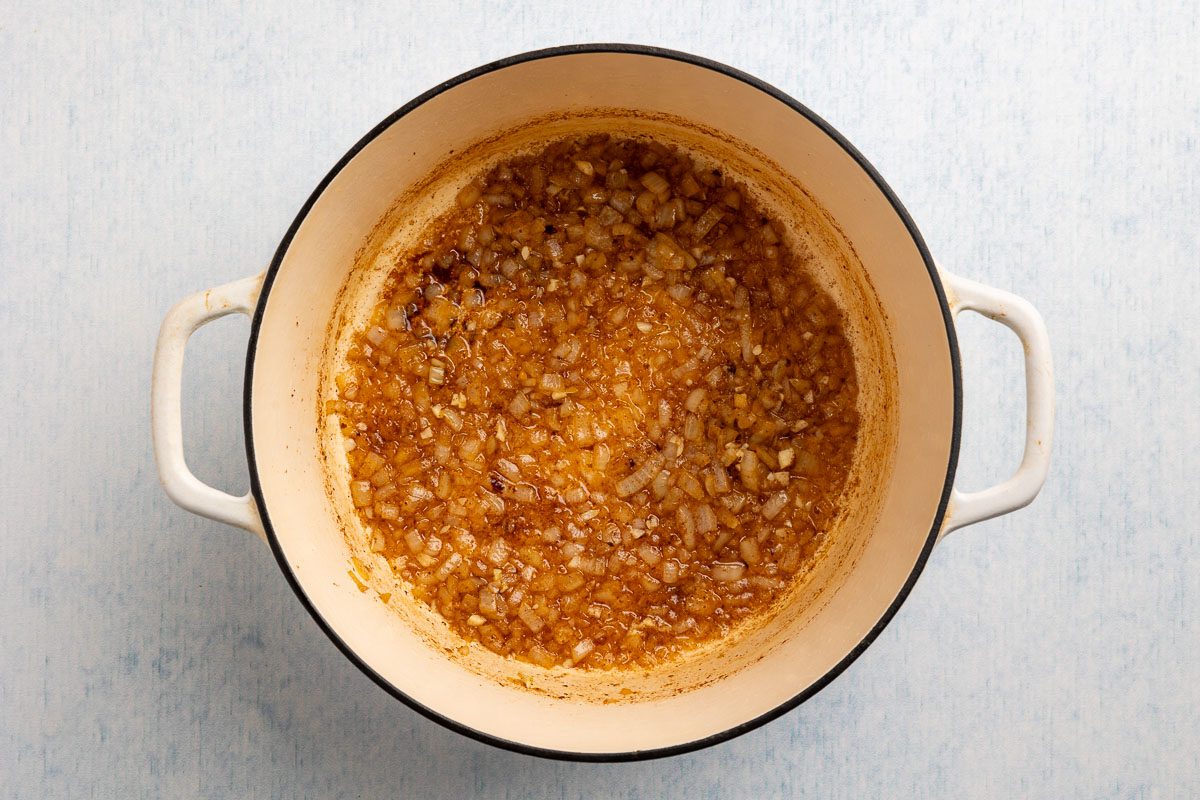 Taste of Home Pinto Bean Recipe photo of garlic and onion sauteed in a dutch oven.