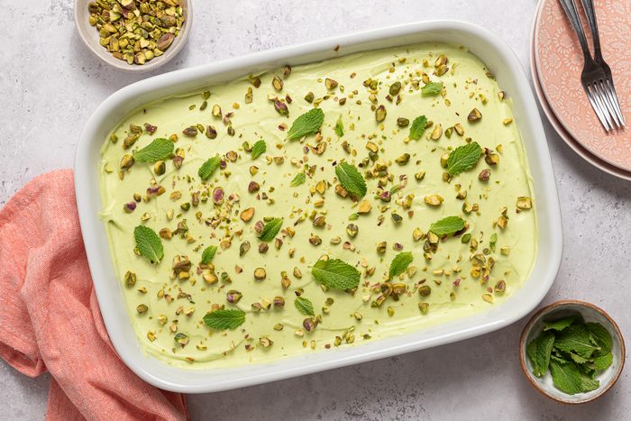 Frosted Pistachio Cake Sprinled With Pistachios And Mint Leaves