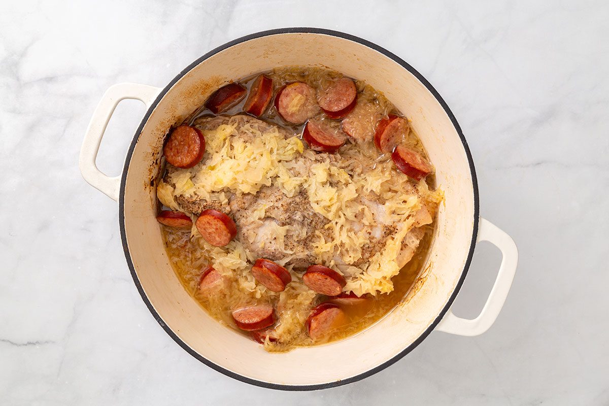 Cooked pork roast resting in the Dutch Oven for step five of Pork Roast and Sauerkraut recipe for Taste of Home