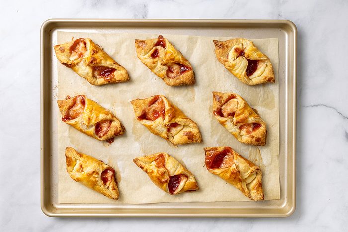 Baked Puff Pastry Danishes on a baking sheet for step four of Puff Pastry Danish recipe for Taste of Home