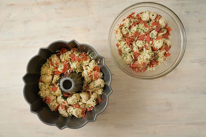 Overhead view of the dough mixture spread in a greased pan and baking in the oven for the Taste of Home Pull Apart Pizza recipe.